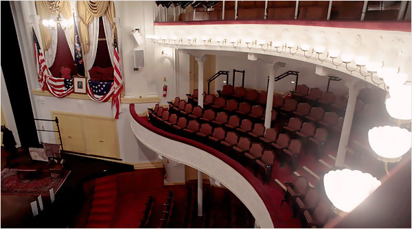 A color photograph of Ford's Theatre looking toward the stage, with the President's box in view. Lincoln's ghost often haunts this stage