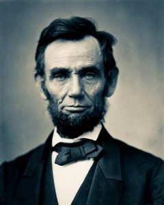 An iconic photograph of a bearded Abraham Lincoln showing his head and shoulders.